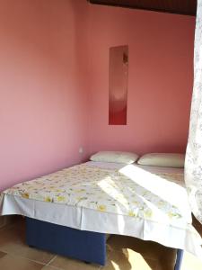 a bedroom with two beds in a pink wall at Apartments Sandra in Lopar