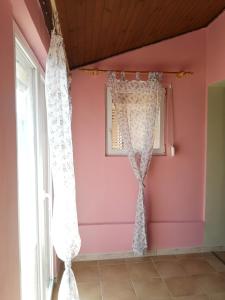 a room with pink walls and a window with curtains at Apartments Sandra in Lopar