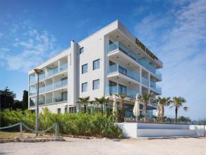 un hotel en la playa con palmeras en Kaneo beach hotel Novalja, en Novalja