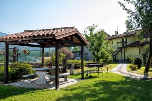 un abri de pique-nique avec des bancs dans un parc dans l'établissement Casa delle rose, à Verbania