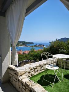 a patio with a table and chairs and the ocean at Luxury apartment Prestige Villa Bellevue in Vis