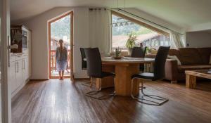a woman standing in a living room with a table and chairs at Ferienwohnung Traudl in Inzell