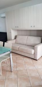 ein Wohnzimmer mit einem weißen Sofa und einem Tisch in der Unterkunft Frontemare Portoscuso in Portoscuso