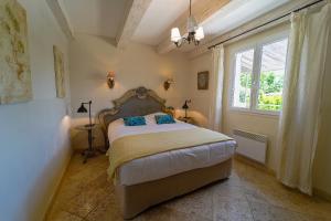 a bedroom with a bed and a window at Les Restanques De Beaudine in Forcalquier