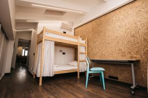 a room with a bunk bed and a chair at Хостел LOFT in Belgorod