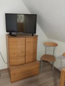 a tv on top of a wooden dresser with a stool at Haus Ursula in Brake