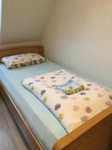 Una cama pequeña con una manta de flores. en Haus Ursula en Brake
