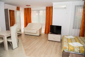 a room with a bed and a chair and a television at Apart Lev in Ravda +159 photos