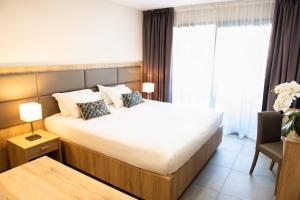 a hotel room with a large bed and a chair at Hotel Residence Lido Marana Bastia Furiani in Furiani