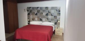 a bedroom with a bed with a red blanket at Agriturismo Colle del Sindaco in Petrizia