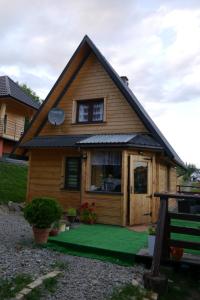 una casa con un césped verde delante de ella en Leśniakówka 693-664-683 en Solina