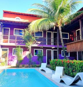 una casa con una piscina y una palmera en Bela Silvia Pousada, en Natal