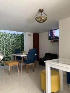 sala de estar con mesa, sillas y TV en Hotel Atardecer Guajiro en Ríohacha