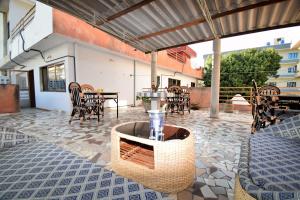 eine Terrasse mit einem Tisch, Stühlen und einer Vase in der Unterkunft B&B Chez Rita in Cotonou