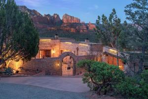 a brick house with a mountain in the background at Private, Modern, Luxury Studio With Unmatched Red Rock Views Private Trail Head - Enjoy on property Sauna, Aromatherapy Steam Room, Hot Tub, Pools and Wellness Services in Sedona