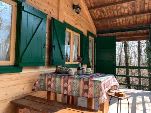 a bedroom with green doors and a table in a cabin at CHALET ETNA MILO in Milo