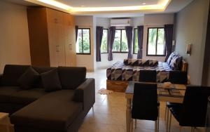 a living room with a couch and a bed at Oasis Apartments & Bar in Karon Beach