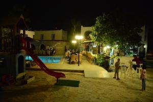 two children standing next to a playground at night at Bodrum Park Hotel in G&uuml;mbet