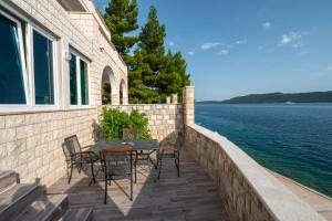 a patio with a table and chairs and the water at Beach Villa Ratac in Slano
