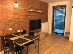a dining room with a table and a tv at Apart Prestige Ząbkowska Old Town in Warsaw