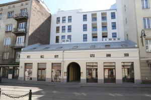 a white building on a street next to buildings at Apart Prestige Ząbkowska Old Town in Warsaw