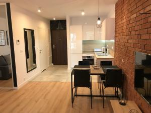 a kitchen with a table and chairs and a brick wall at Apart Prestige Ząbkowska Old Town in Warsaw