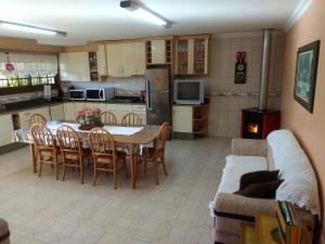 eine Küche und ein Wohnzimmer mit einem Tisch und einem Sofa in der Unterkunft Casa das Palmeiras + Quiosque in Bento Gonçalves