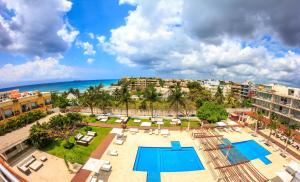 an aerial view of a resort with a swimming pool and the ocean at Magia Beachside Apartment by BVR in Playa del Carmen