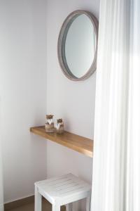 a mirror on a shelf next to a white curtain at The Wave in Sidari