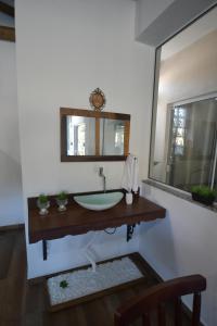 y baño con lavabo y espejo. en Pousada Barra Sul, en Laguna