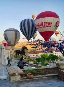 a group of hot air balloons flying in the sky at Phocas Cave Suites in Göreme