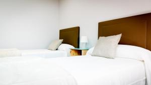 A bed or beds in a room at Apartamentos Villa Zoila Baiona