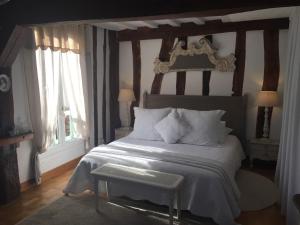 a bedroom with a large bed with a wooden headboard at B&B les Agapanthes in Gasny