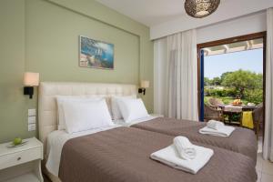 a bedroom with a large bed with towels on it at The Wave in Sidari