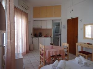 a kitchen and dining room with a table and chairs at Kallithea Studios in Rethymno Town