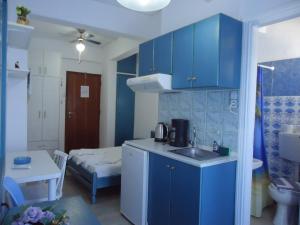 una cucina con armadi blu e un lavandino in camera di Kallithea Studios a Rethymno