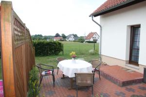 un patio con mesa, sillas y una valla en Ferienwohnung Kranichnest en Malschwitz