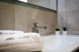 bagno con lavandino e vasca con asciugamani di Ciasa MAEL Dolomites Apartments a La Valle