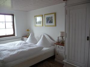 1 dormitorio con 1 cama con sábanas blancas y ventana en Ferienwohnung Kranichnest en Malschwitz