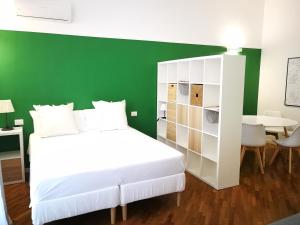 a bedroom with a white bed and a green wall at Carulli 69 - Check-in Express apartments in Bari