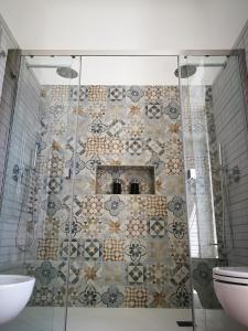 a bathroom with a shower with a tile wall at Carulli 69 - Check-in Express apartments in Bari