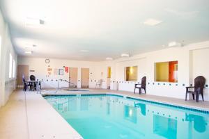 una piscina con sillas y mesas en un edificio en Motel 6-Las Cruces, NM - Telshor en Las Cruces