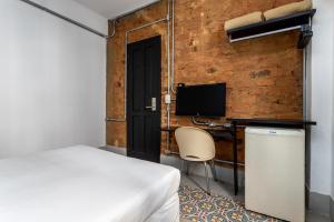 um quarto com uma cama e uma secretária com um computador em Hotel Monte Castelo no Rio de Janeiro