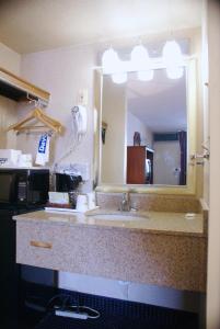 a bathroom with a sink and a large mirror at Days Inn by Wyndham Arlington Pentagon in Arlington