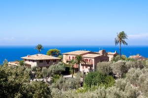 a house on a hill with the ocean in the background at Hoposa Costa D'or - Adults Only in Deia