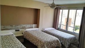 a room with three beds and a window at Apartamento Benidorm Luxury Levante in Benidorm +34 photos