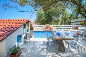 a patio with a table and chairs next to a building at Agyrovoli Bungalow in Skala Kallirachis