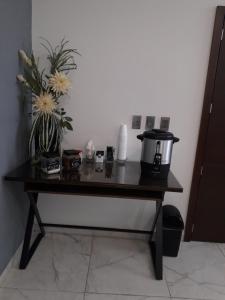 a table with a coffee pot and flowers on it at Hotel Corral Grande in Jamay