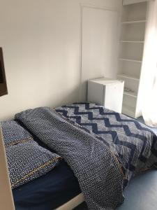 - un lit avec une couette bleue dans une chambre dans l'établissement CHAMBRE INDIVIDUELLE CHEZ SANDRINE A 20 min des Portes de PARIS, à Saint-Gratien