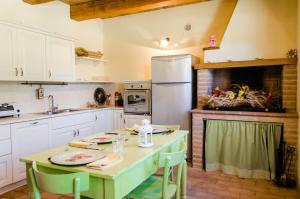 cocina con mesa, fregadero y nevera en Agriturismo Pompagnano, en Pompagnano